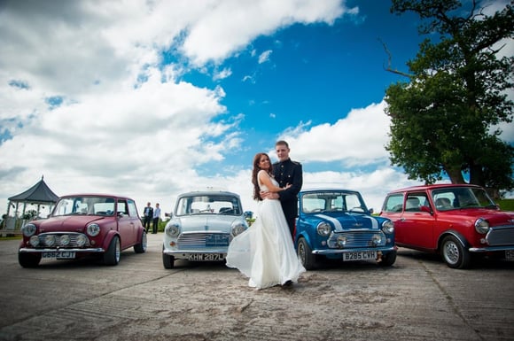 Bride and groom with classic mini car